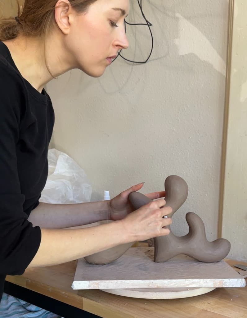 Portrait of Emily Meisler working on a sculpture in the studio